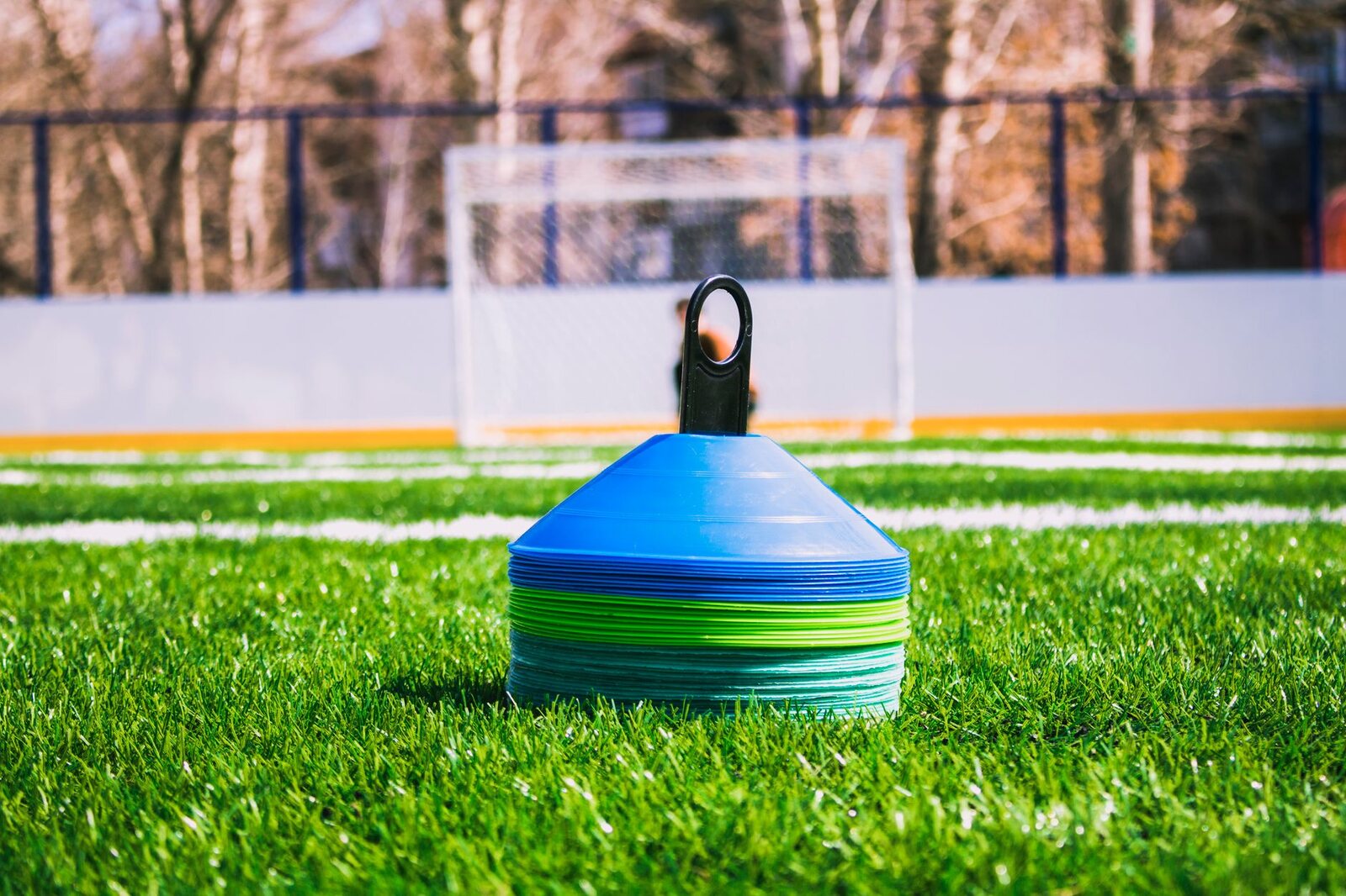 Training cones on an empty grassroots pitch, with a goal behind