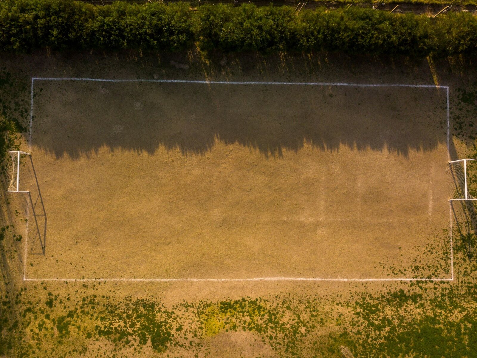 Drone shot of an empty soccer field in Buenos Aires showing light and shadow play.